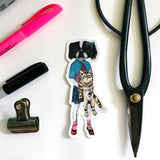 Flat lay of sticker with office supplies. Vintage clothes wearing dog holding a cat. Dog and cat friends