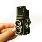 Hand holding an antique camera sticker