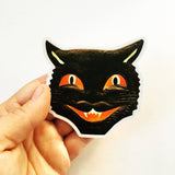 Hand holding vintage cat face sticker