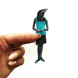 Hand holding a dressed up black crow sticker