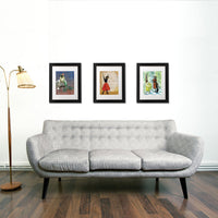 Colorful framed art prints above a modern couch by Pergamo Paper Goods