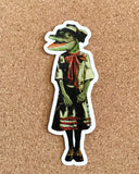 Retro alligator decal on cork background. Alligator is wearing a 1920s style dress.