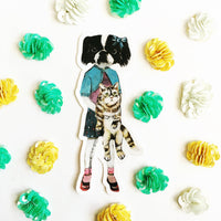 Japanese Chin illustrated vinyl sticker. Dog wearing clothes with a cat. Photograph has sticker surrounded by sequins.