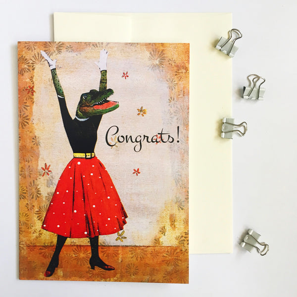 Vintage illustration of a dressed up alligator, arms in the air, with a red polka dot skirt. Text says "Congrats!" Pergamo Paper Goods