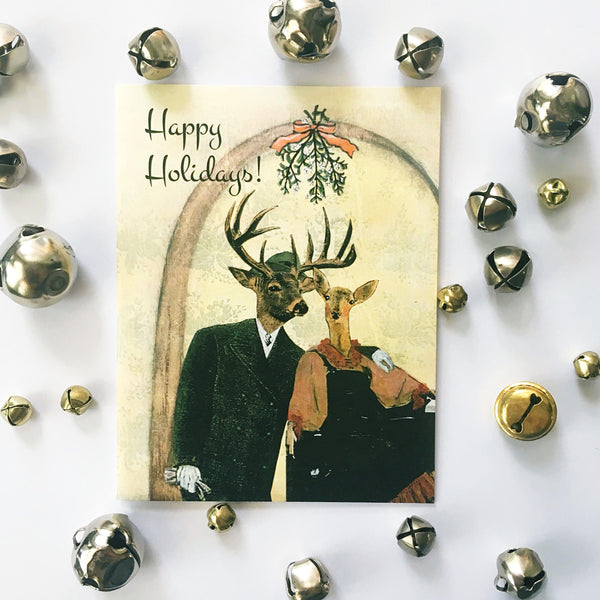 Illustrated holiday card, dressed up deer couple under the mistletoe, Text reads Happy Holidays. Animal cards, mixed media animal art