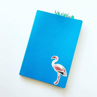 Flamingo vinyl sticker on a blue notebook. Antique flamingo