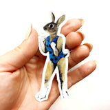 Hand holding illustrated rabbit sticker. Mixed media rabbit with human body and swimsuit. Retro vinyl sticker, laptop sticker