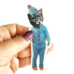 Handmade Kitten Vinyl Sticker being held. Kitten is dressed up in vintage blue pajamas with a hat.
